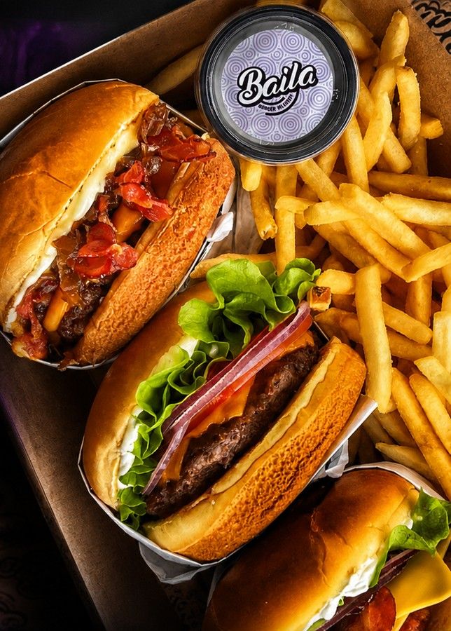 Três burgers artesanais Baila com batatas fritas, servidos em caixa com pote de molho personalizado
